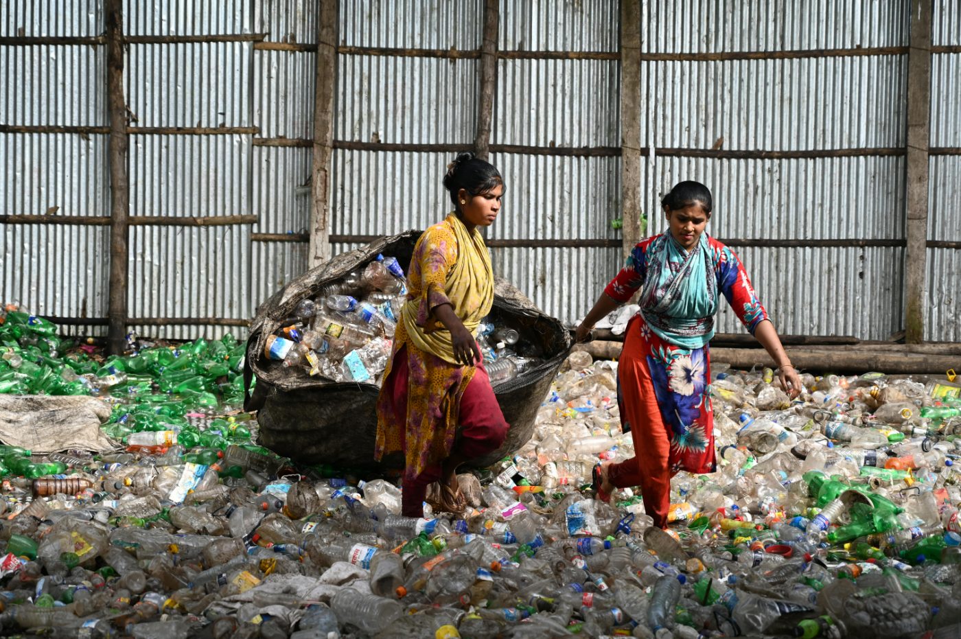 Two waste pickers gathering plastic bottles for recycling